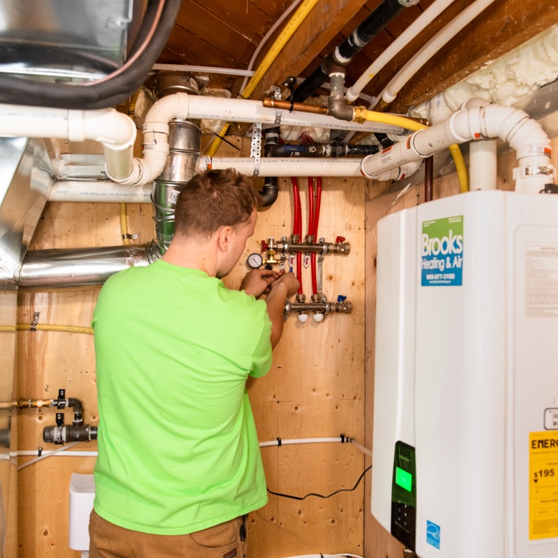 Brooks technician working on a high-efficiency boiler and water softener