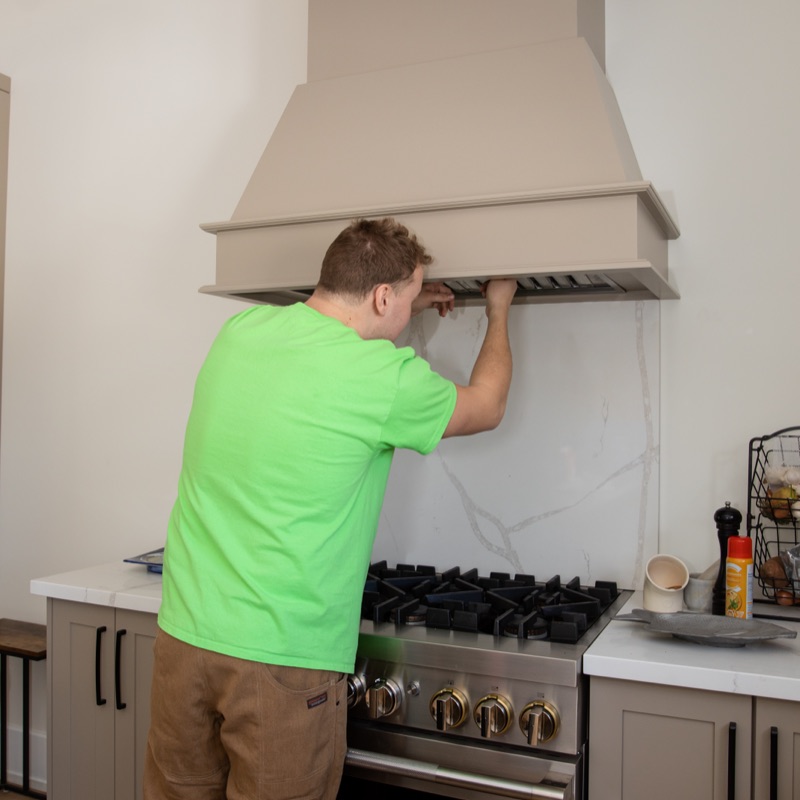 Brooks technician installing a kitchen range-hood vent